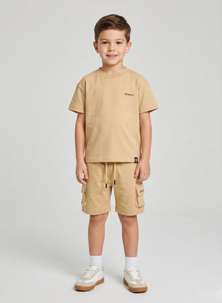 Boy wearing a beige short-sleeve T-shirt with matching cargo shorts featuring side pockets and a drawstring waist.