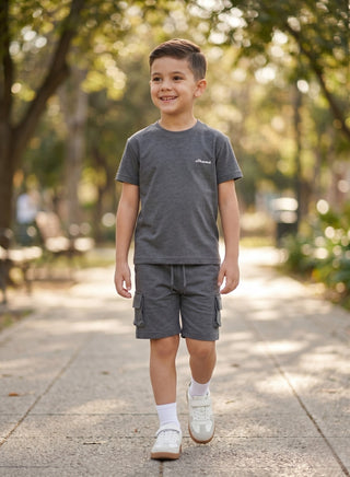 Boy wearing a beige short-sleeve T-shirt with matching cargo shorts featuring side pockets and a drawstring waist.