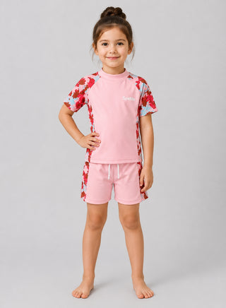 Girl wearing pink swim top and shorts with red, pink and blue camo print on sleeves and sides