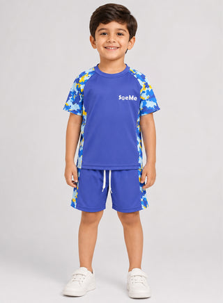 Boy wearing blue short-sleeve swim top and shorts with blue and yellow camo print panels