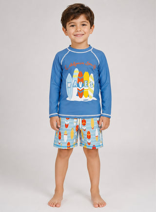 Boy wearing blue long-sleeve rash guard with surfboard print and matching surfboard-print swim shorts