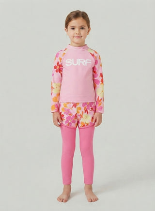 Girl wearing pink Surf rash guard with floral sleeves, floral swim shorts and pink leggings