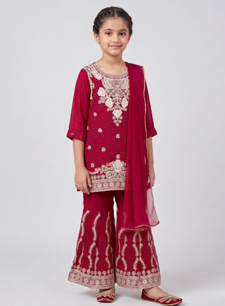 Girl wearing a red embroidered sleeveless kurta with matching Patiala salwar, chiffon dupatta, and coordinating handbag ethnic wear set for kids aged 4–12 years.